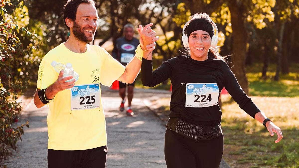 Happy runners celebrate finishing a race outdoors, showcasing team spirit and fitness.